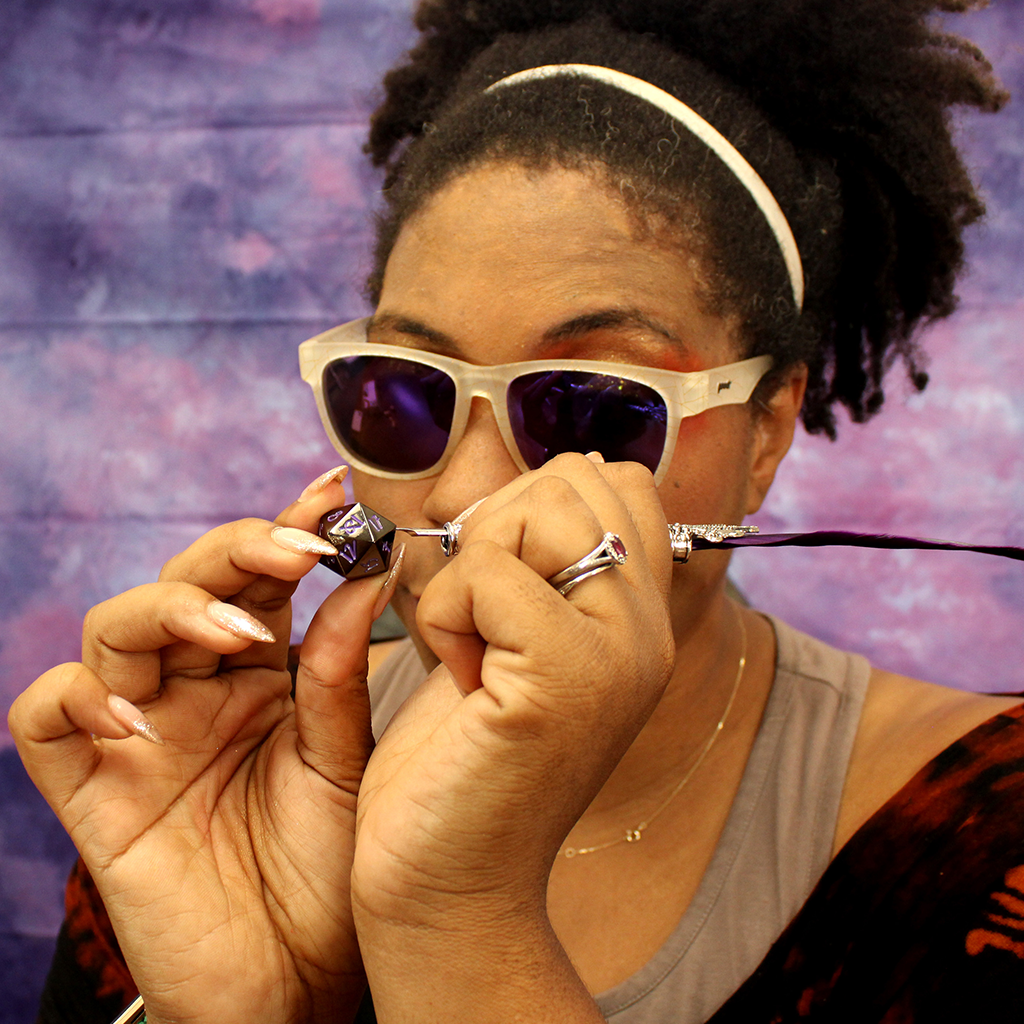 Image of Aabria Iyengar handpainting the numbers onto a dice.